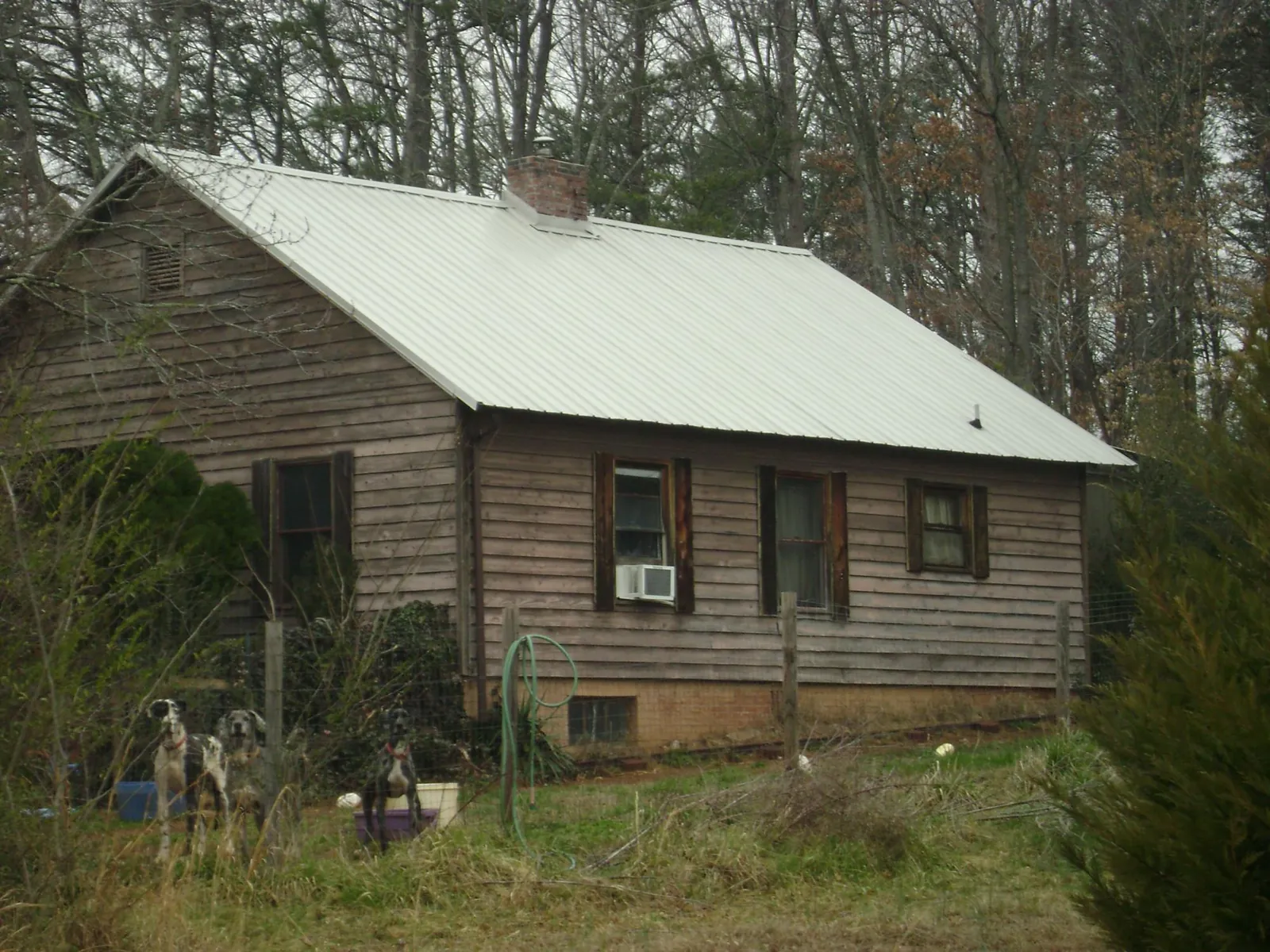 White metal roof on an old wood sided farmhouse, from a Metal Roof Installation job in Hoskins